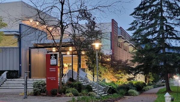 Exterior view of a building labeled “Service Center,” illuminated in the early evening, with surrounding greenery and a sidewalk in front—showcasing the attention to detail valued by Bradbury Miller Associates (BMA).