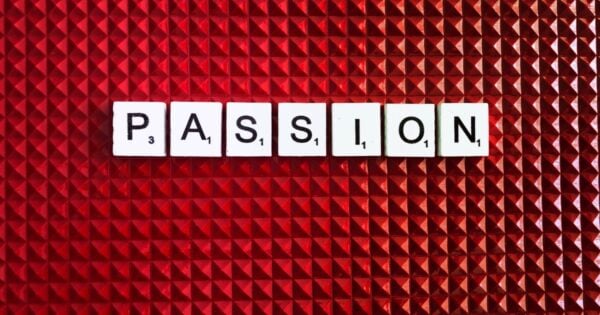 Scrabble tiles spelling the word passion on a red background.