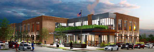 Modern two-story brick building with large windows, an American flag, outdoor seating, greenery, and people walking and cars parked in front under a cloudy sky—an inviting community space by BMA | Bradbury Miller Associates.
