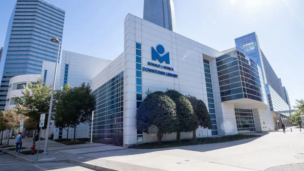 Modern medical building with glass and white panel exterior, displaying the sign "Ronald J. Norick Downtown Library," surrounded by high-rise buildings and trees, represented by BMA Bradbury Miller Associates.